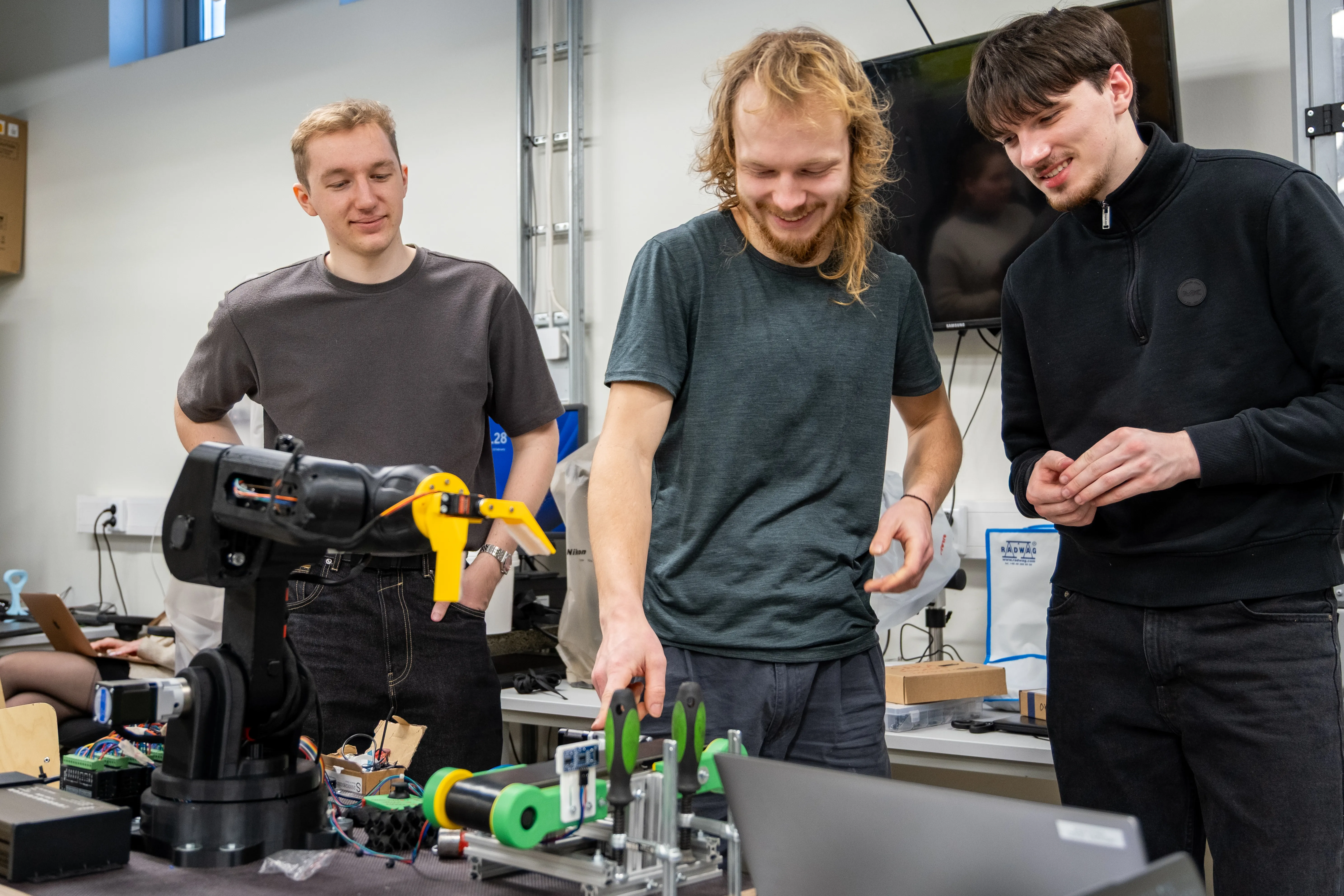 Three students are working with Proto-GK-RA robot.